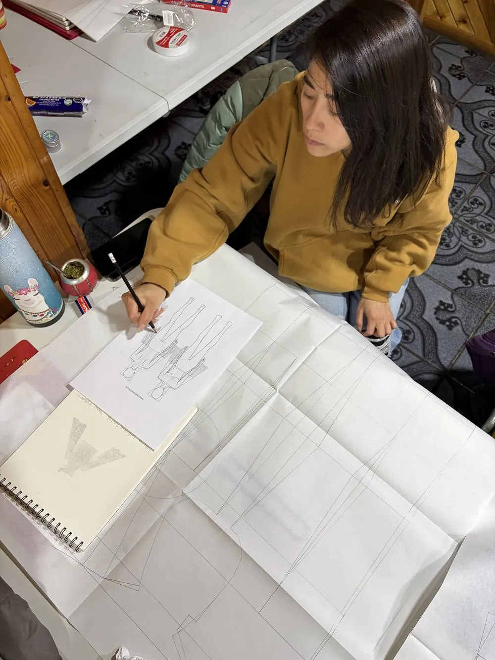 Carola Mansilla dibujando el diseño de una pieza, Coyhaique